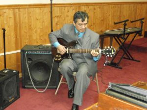 Rev Dervis Hernandez playing the guitar